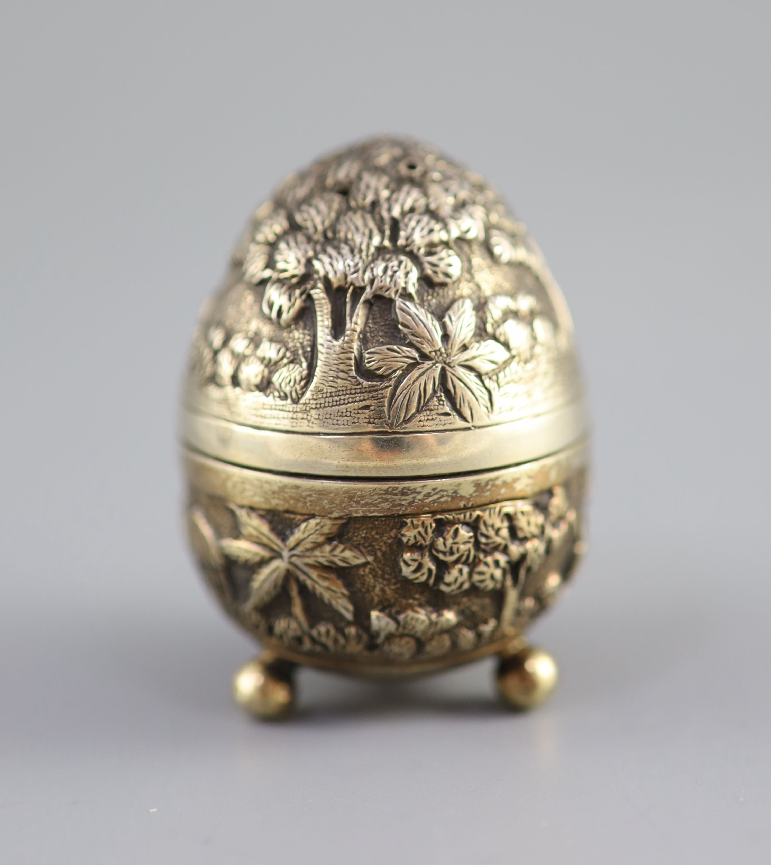 A graduated pair of Edwardian novelty silver gilt condiments, modelled as eggs, with bird's nest interior including two 'marbled' eggs